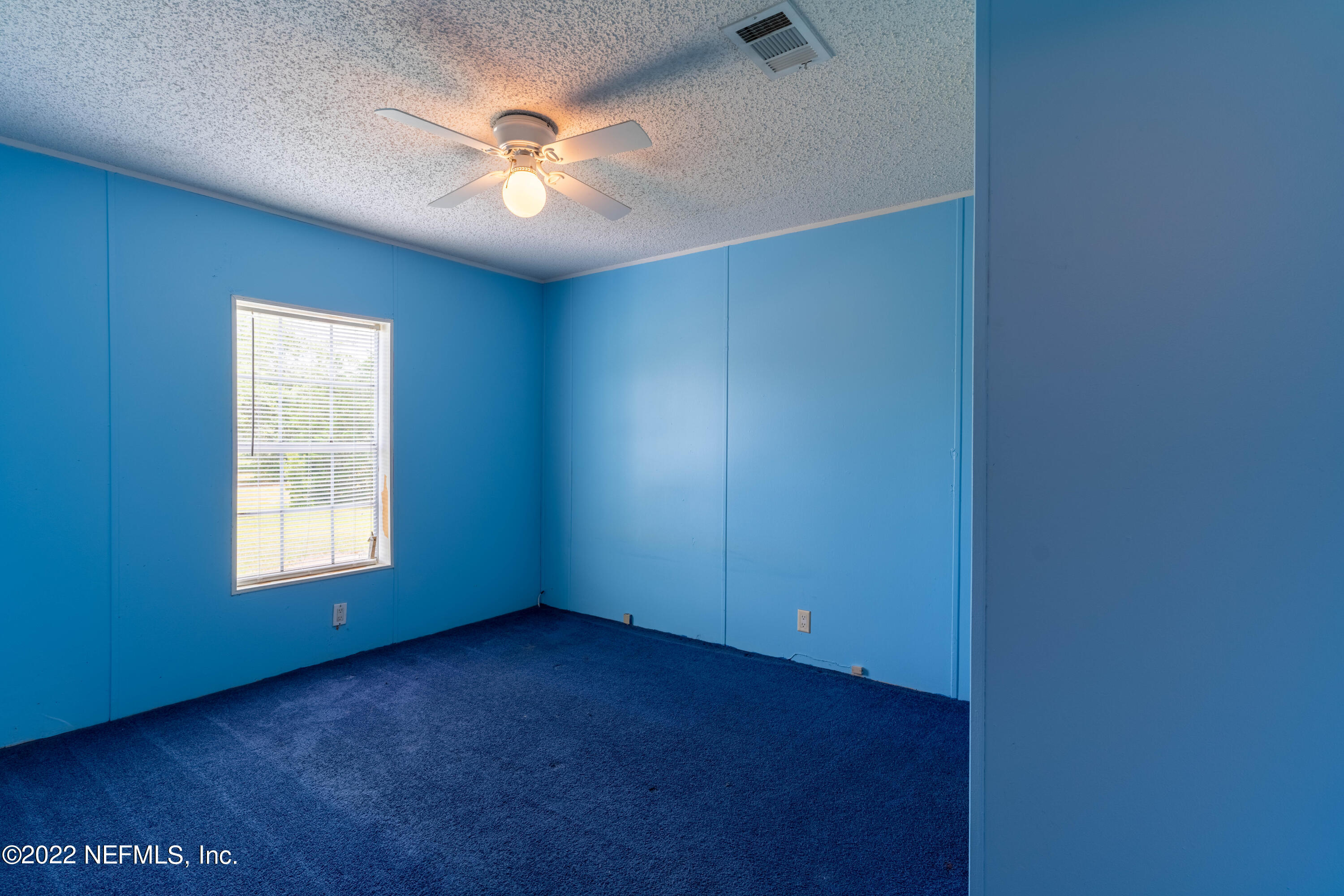 19697 Crews Road Glen St. Mary, FL 32040 - Photo 19 of 25 an empty room with windows and chandelier fan
