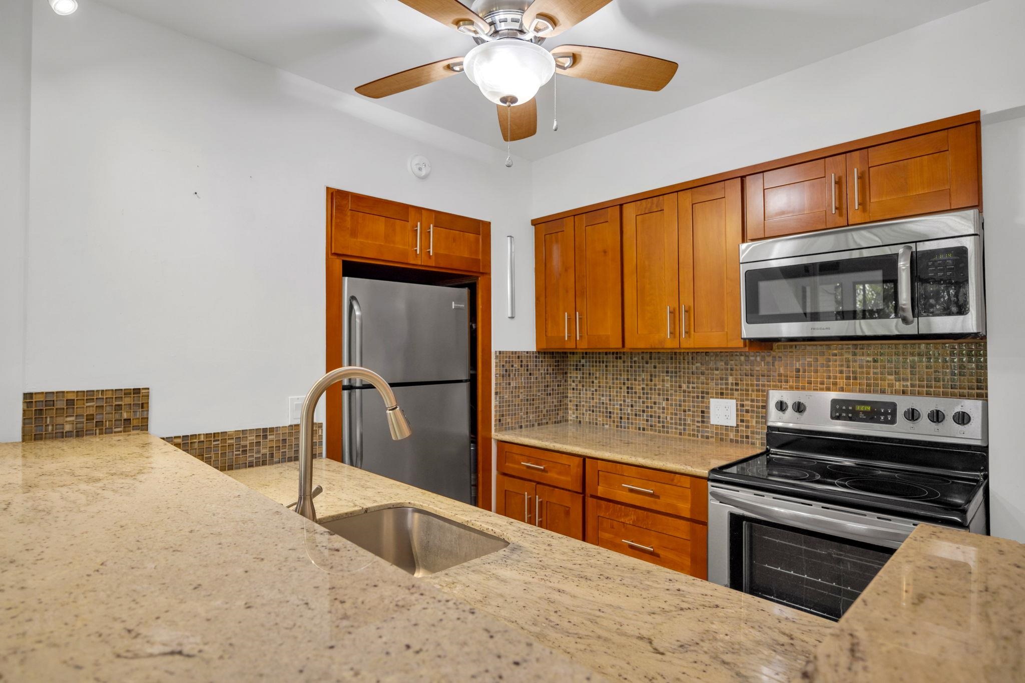 a kitchen with stainless steel appliances granite countertop a sink and cabinets