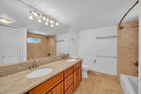 a bathroom with a granite countertop sink a mirror and a bathtub