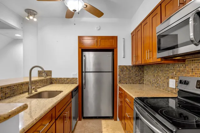 a kitchen with stainless steel appliances granite countertop a sink stove and refrigerator