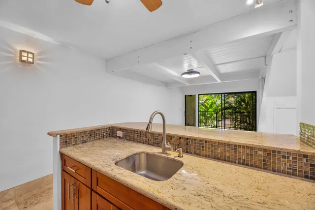 a kitchen with a granite countertop sink and a window