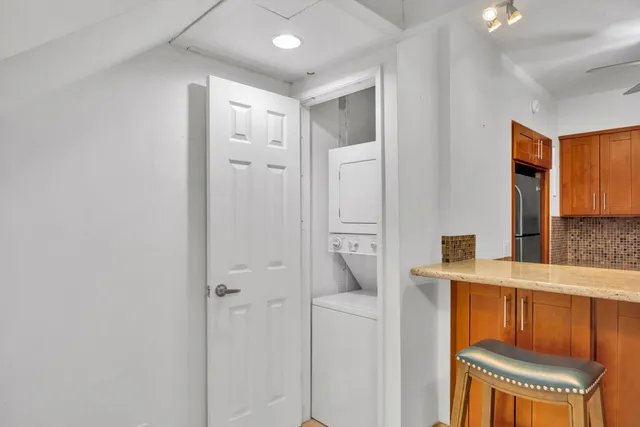 a hallway with a door and a refrigerator