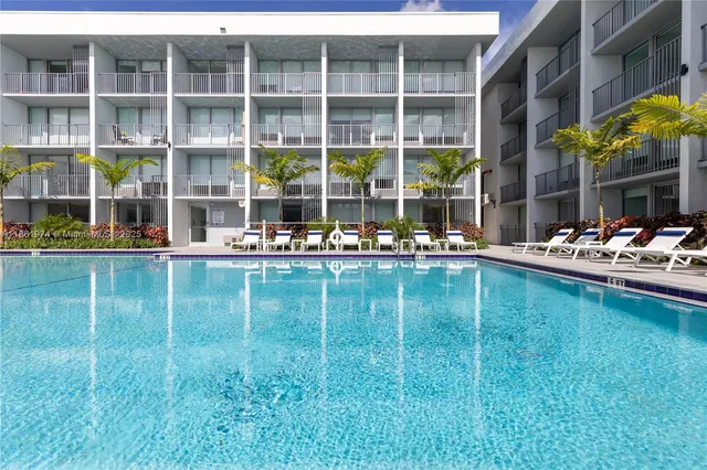 a swimming pool view with a outdoor seating space and a garden view