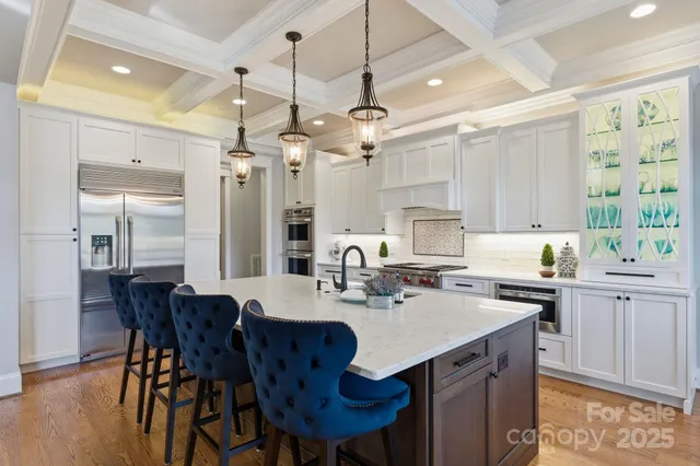 a kitchen with a dining table chairs stainless steel appliances and cabinets