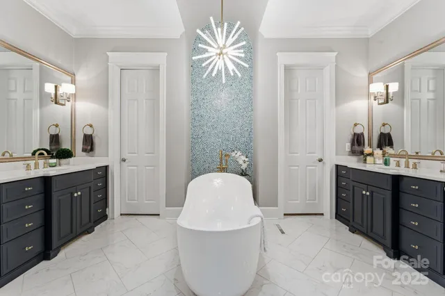 a spacious bathroom with a double vanity sink a mirror a bathtub and a window