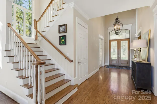 a view of a hallway with wooden floor and staircase