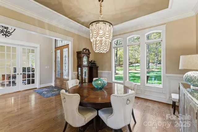 a dining room with furniture a chandelier and wooden floor