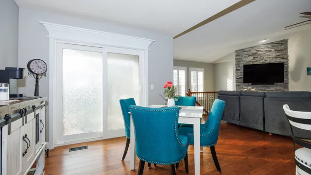 a kitchen with a dining table chairs and refrigerator