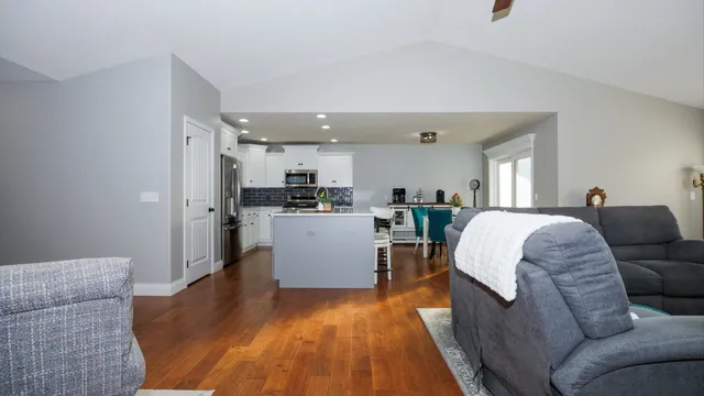 a living room with a couch and kitchen view