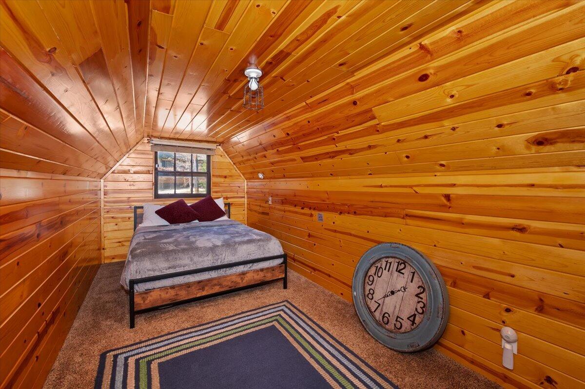 39187 Arapahoe Road Fawnskin, CA 92333 - Photo 21 of 33 a bedroom with a bed and a table in it
