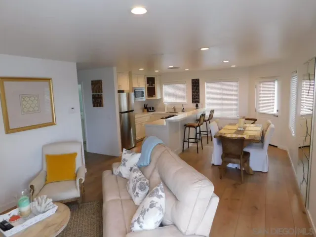 a living room with lots of furniture and kitchen view