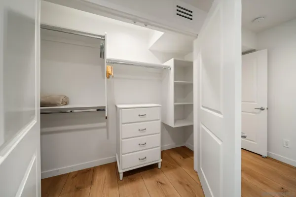 a spacious bedroom with a bed and wooden floor