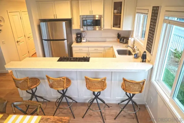 a kitchen with a table chairs refrigerator and microwave