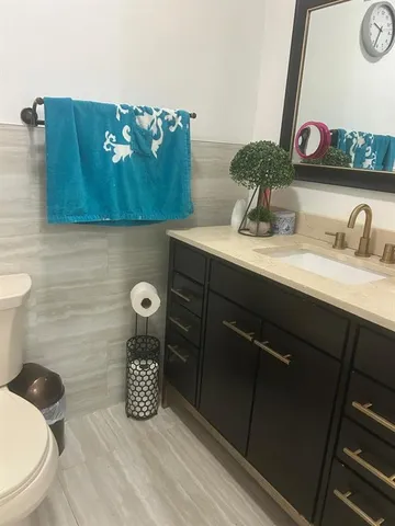 a bathroom with a toilet sink and mirror