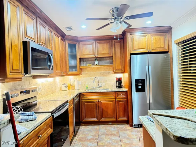 a kitchen with stainless steel appliances granite countertop a sink stove and refrigerator