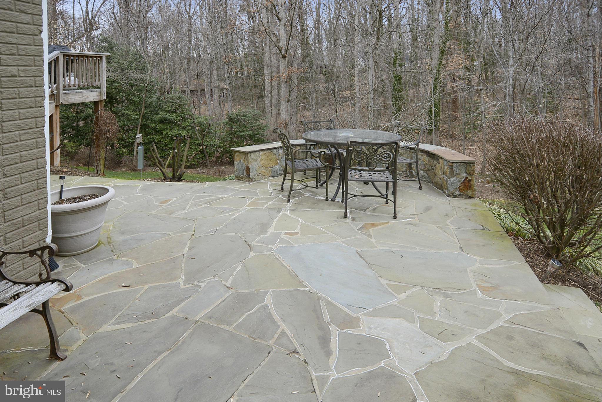 7406 Spring Summit Road Springfield, VA 22150 - Photo 26 of 30 a view of a patio with table and chairs potted plants with wooden fence