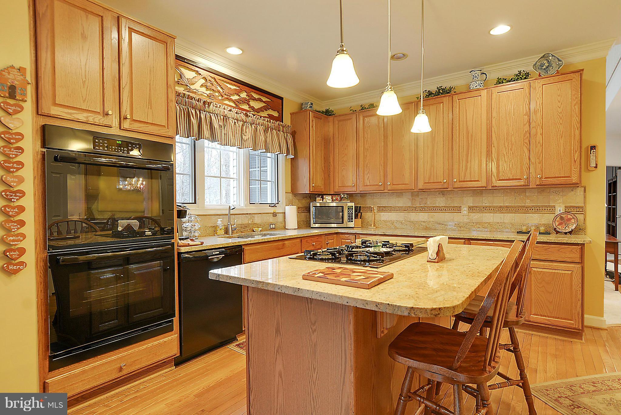7406 Spring Summit Road Springfield, VA 22150 - Photo 10 of 30 a kitchen with a table chairs sink and cabinets