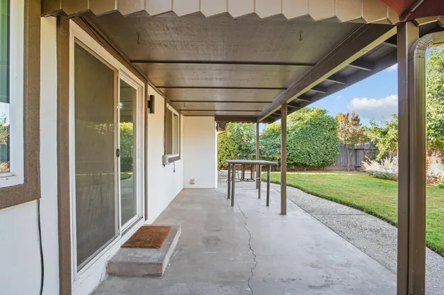 a view of a porch with chairs and backyard
