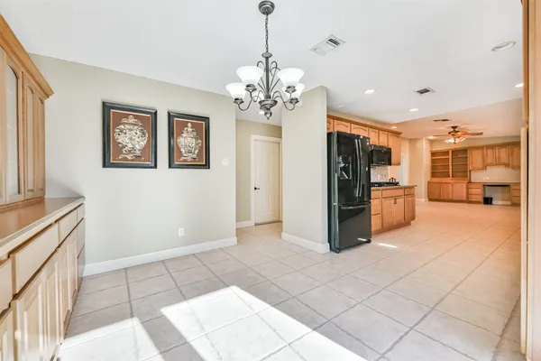 a view of a kitchen with refrigerator and a stove top oven