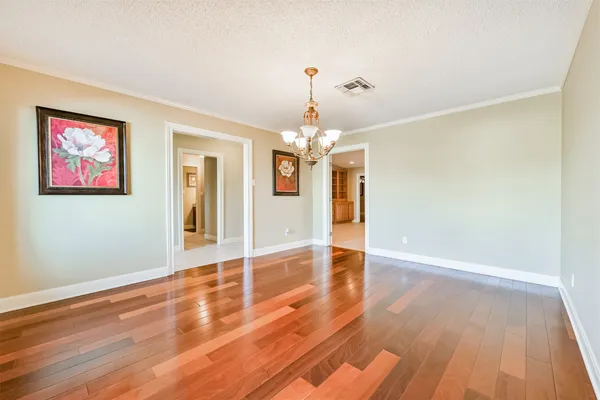 a view of a room with wooden floor chandelier and a window
