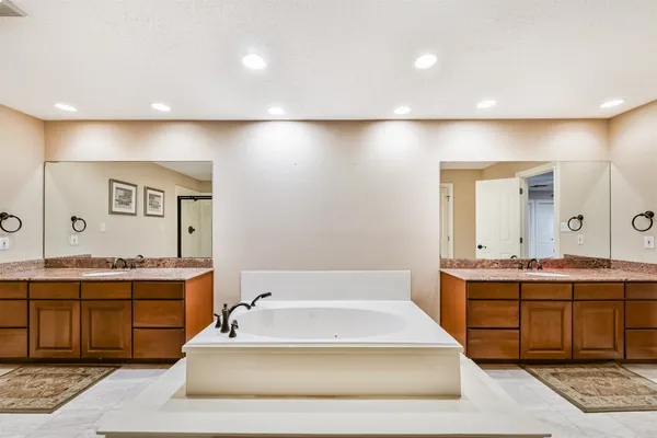 a spacious bathroom with a tub sink and mirror