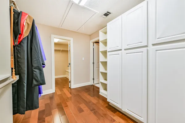 a view of walk in closet with clothes and shoes