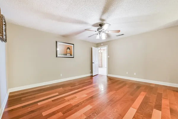a view of an empty room with wooden floor