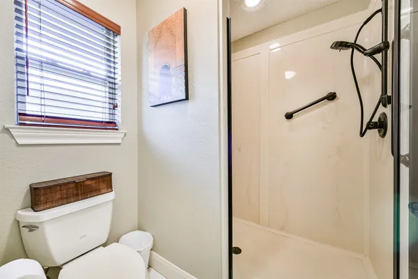 a bathroom with a toilet and a shower