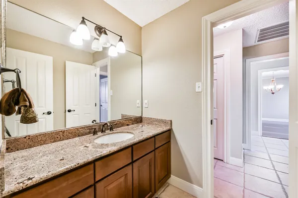 a bathroom with a granite countertop sink and a mirror