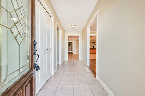 a view of a hallway with wooden floors and cabinet