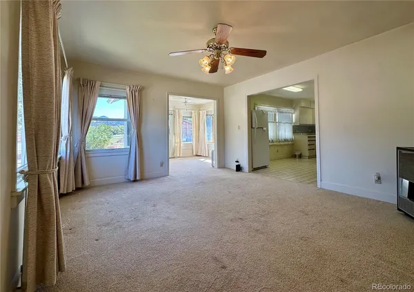a view of a hallway with wooden floor and a living room