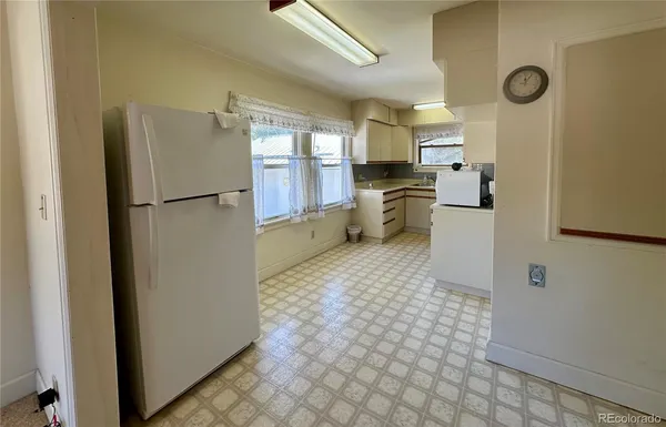 a bedroom with a bed a mirror on dresser and a flat screen tv