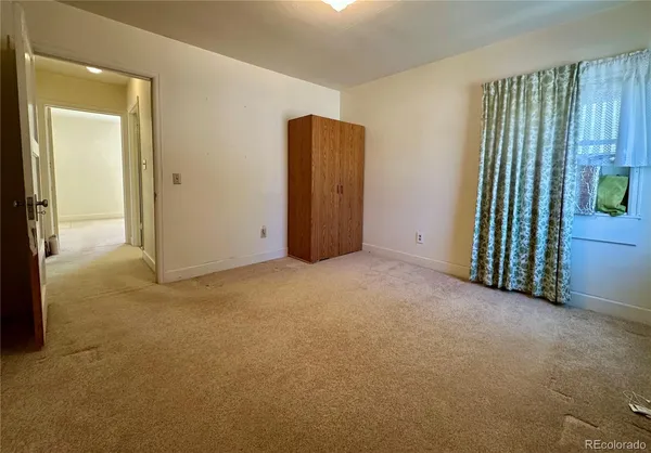 a bed sitting in a bedroom next to a window
