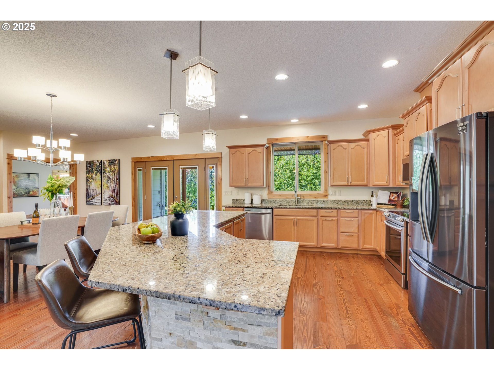 30076 Southeast Cemetery Road Estacada, OR 97023 - Photo 9 of 38 a kitchen with stainless steel appliances granite countertop a refrigerator a sink dishwasher a dining table and chairs with wooden floor