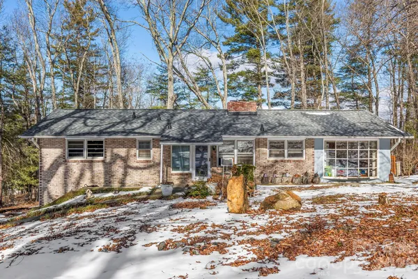 a front view of a house with a tree