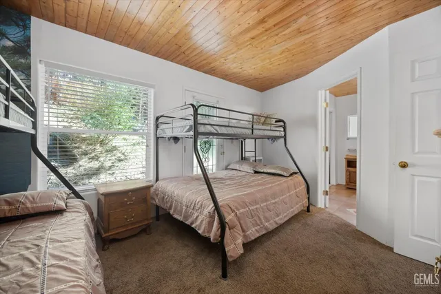 a bedroom with a bed lamp and a large window