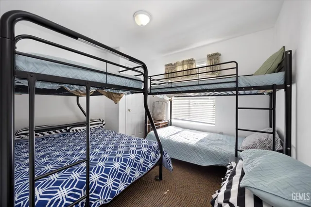 a bedroom with a bed next to a window