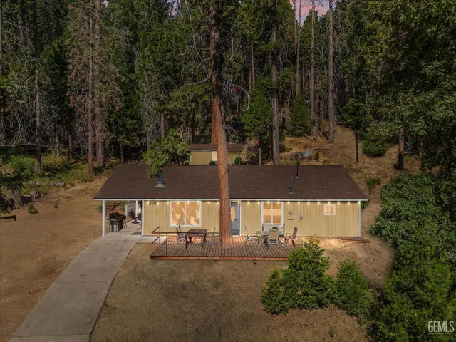 an aerial view of a house with a yard and tree s