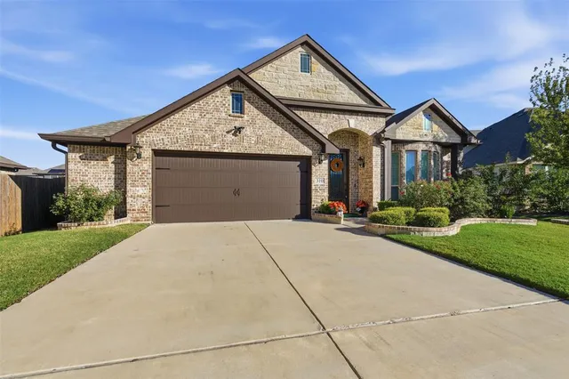 a front view of a house with yard and garage