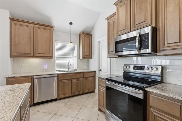 a kitchen with stainless steel appliances granite countertop a sink stove and microwave