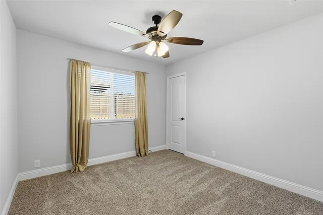 an empty room with closet and a chandelier fan