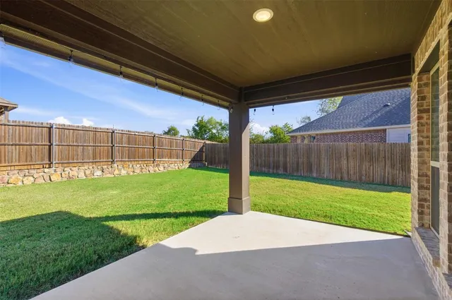 a view of a backyard with wooden fence