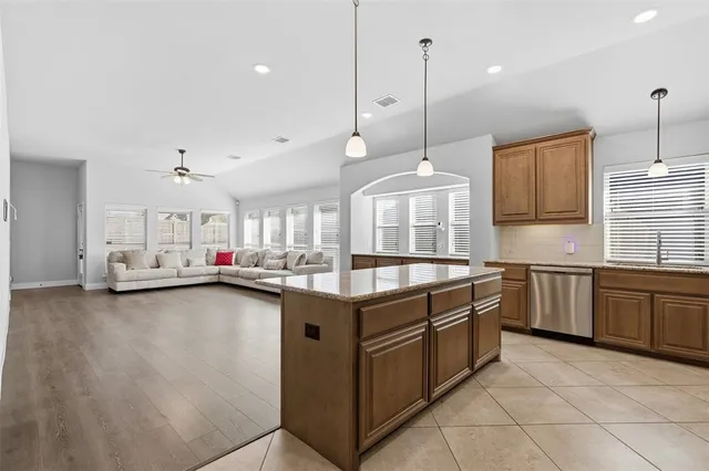 a kitchen with granite countertop a sink a counter space appliances and cabinets