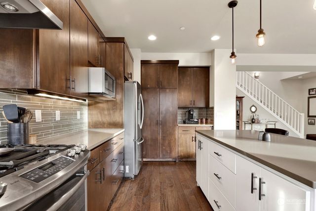 a kitchen with kitchen island granite countertop a sink stainless steel appliances and cabinets
