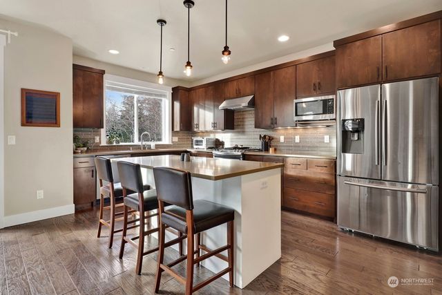 a kitchen with stainless steel appliances a refrigerator a stove a sink and a microwave