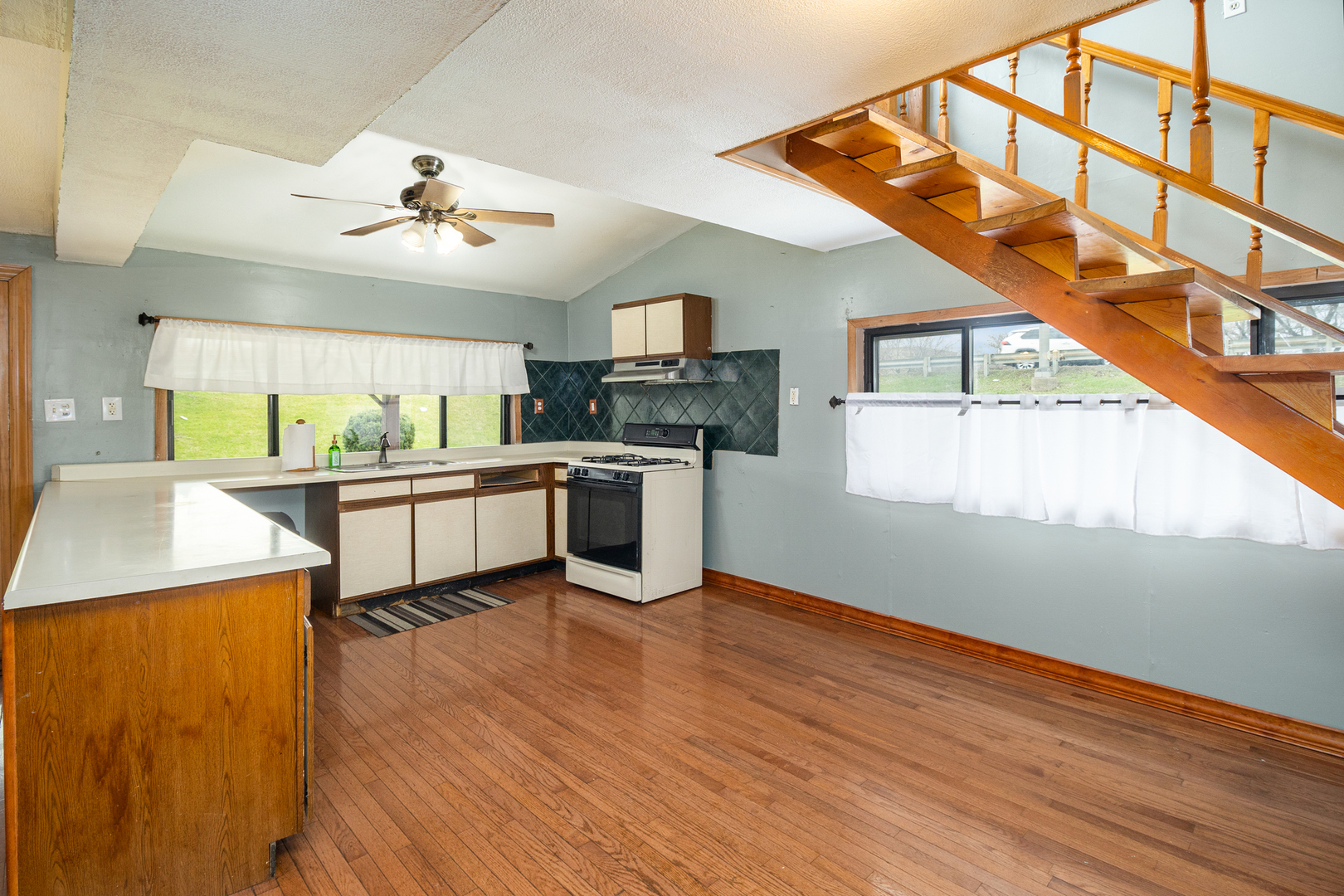 818 Clinton Street Lockport, IL 60441 - Photo 4 of 23 a view of a kitchen with kitchen island a sink wooden floor and a living room