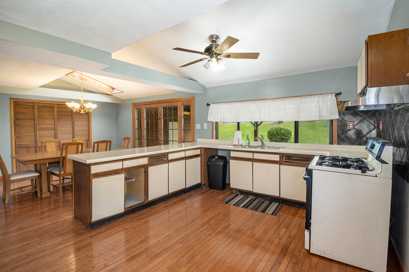 818 Clinton Street Lockport, IL 60441 - Photo 5 of 23 a kitchen with a sink cabinets wooden floor and stainless steel appliances