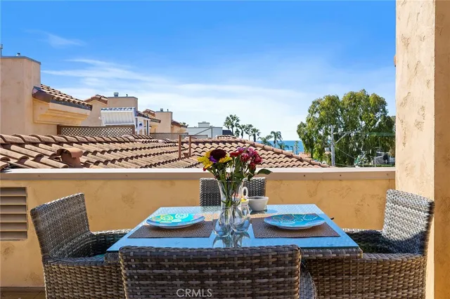 a view of an outside dining space with furniture and umbrella