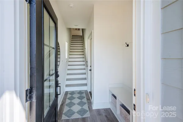 a view of a hallway with wooden floor and stairs