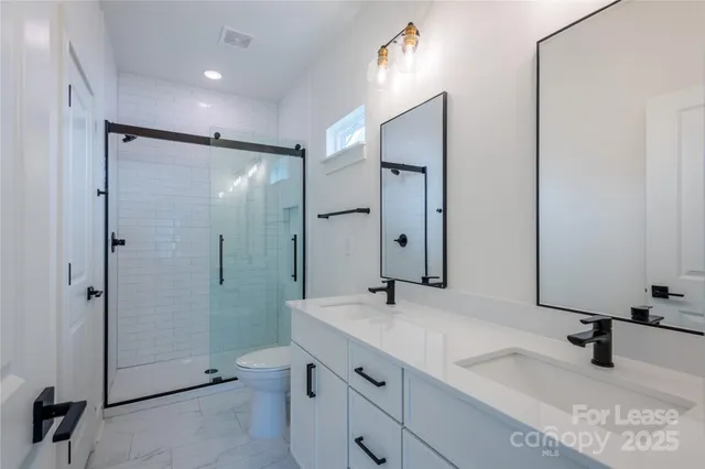 a bathroom with a double vanity sink mirror and shower